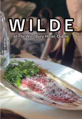 A review of Wilde at The Westbury Hotel in Dublin, featuring a variety of dishes including carpaccio, scallops, burrata, and salmon, alongside cocktails. The video provides a clear look at the menu and the dining atmosphere.