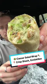 A creator reviews a Caesar salad wrap from a food truck called The Crisp Shack in Enniskillen, sitting in his car. He describes the ingredients, the texture, and the price, providing a positive review of the viral item.