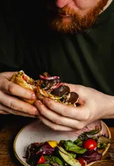 A behind-the-scenes reel showcasing a professional food photography session at a brunch venue. The video intercuts shots of the photographer and model with high-quality, close-up footage of the plated dishes and drinks, creating a polished and inviting aesthetic.