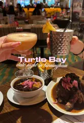 A short, upbeat video showcasing a date night experience at Turtle Bay. The edit features quick cuts of the restaurant's interior, various cocktails, and Caribbean-inspired dishes like jerk chicken and wings, set to a rhythmic soundtrack.