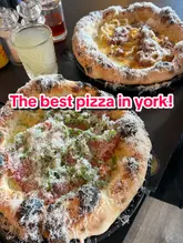 A short, punchy video showcasing the pizza-making process at Dough Eyed Pizza in York, featuring close-ups of toppings, cheese grating, and finished cocktails.