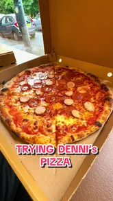 A lively, vlog-style review of Denni's in Glasgow, featuring two creators tasting a variety of menu items including pizza, chicken tenders, mozzarella sticks, fries, and dessert balls. The video highlights the food preparation and the casual, welcoming vibe of the venue.