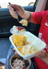 A creator reviews a selection of desserts and a drink from 'Brownie Fusion' while sitting in their car, providing taste and texture notes for each item.