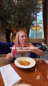 The video features a creator visiting The Cut and Craft in Manchester, showcasing the restaurant's elegant interior, including its chandeliers and bar area. The creator highlights several dishes, including steak and fish and chips, while explaining how to use the First Table app to get a discount on the meal.