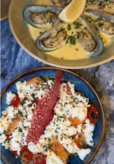 A creator visits Zeus Taverna in Liverpool to highlight their affordable two-course meal deal and small plates offer. The video features shots of the restaurant interior, the food, and the creator enjoying the experience.