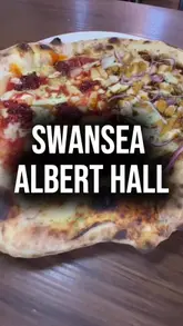 A vlog-style review of Albert Hall in Swansea, featuring the two creators exploring the venue, explaining the QR code ordering system, and showcasing food from various vendors.
