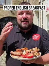 A food review video featuring a creator showcasing a 'proper' English breakfast at Aubrey & Co in Sowerby Bridge, highlighting homemade components like beans and hash browns.