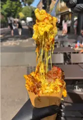 A food review of The Axe & Ember Smokehouse in London, featuring their signature mac and cheese cones, smoked brisket, short ribs, and various sides. The video uses a first-person perspective to showcase the texture and quality of the smoked meats and the preparation process.