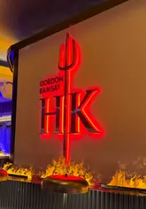The creator documents their experience at the launch party of Gordon Ramsay's Hell's Kitchen restaurant at The Cumberland Hotel in London. The video features a mix of direct-to-camera commentary, shots of the venue's interior, and close-ups of various canapés and dishes, including beef wellington, lobster risotto, and sticky toffee pudding.