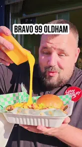 A food review video featuring a creator showcasing various brisket-based dishes, including loaded fries, smash burgers, and sandwiches, from a street food venue called Bravo 99 in Oldham.