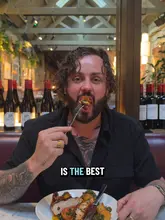 A video review of The Dunmore restaurant, featuring the creator sampling various dishes including peri-peri chicken, a burger, mussels, burrata, and a strawberry souffle, while highlighting the interior and the value of their set menu.