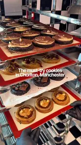 A promotional video for Kuki, a cookie shop in Chorlton, Manchester, featuring close-ups of freshly baked chunky cookies, the shop's interior, and the serving process with milk and ice cream.