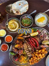 A review of the 'Mangal Sunday' platter at Roya in Glasgow, featuring a large charcoal-grilled meat platter with various sides, dips, and a pistachio dessert.