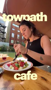 A personal vlog-style review of Towpath Cafe in London, highlighting the canal-side atmosphere, the no-reservation policy, and a selection of dishes including salads and ice cream.