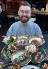 A review of a Japanese restaurant featuring a large, visually impressive sushi platter, wagyu, and various small plates, set in an outdoor dining area.