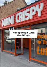 A promotional video announcing the opening of a new Miami Crispy branch in Luton, featuring shots of the exterior, interior, and their signature spicy dip burger.