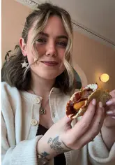 A creator reviews a brunch menu at Bodega in Edinburgh, highlighting their breakfast tacos and the fact that the entire menu is gluten-free. The video features shots of the food, the menu, and the venue interior.