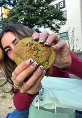 A creator reviews a 'Too Good To Go' bag from Blank Street, revealing a selection of pastries and a cookie. The video focuses on the value and quality of the items received.