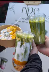 A short, energetic video showcasing a 'mango sticky rice matcha' drink and dessert at a market stall. The video features quick cuts of the preparation process, including whisking matcha and layering ingredients, highlighting the visual appeal of the fusion product.