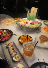A video showcasing a dinner date experience at Gilgamesh, featuring various dishes like sushi, popcorn shrimp, and cocktails.