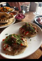 A short, fast-paced reel showcasing a dinner experience at Mesen in Cardiff, highlighting a variety of shareable small plates including dips, skewers, tacos, and seafood, paired with cocktails.
