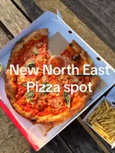 A creator visits the newly opened 'Stupid Good Pizza' in Newcastle, showcasing their pizza, dips, and fries, and enjoying them by the quayside.