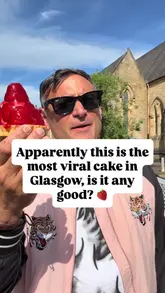 Two creators visit Eusebi Deli in Glasgow to review a viral strawberry tart. They discuss the appearance, taste, and texture of the cake, ultimately giving it a high rating.