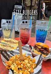 A fast-paced montage showcasing various burgers, a Philly cheesesteak sandwich, loaded fries, and branded drinks from a street food stall in Camden Town. The video focuses on close-up, appetizing shots of the food to entice viewers.