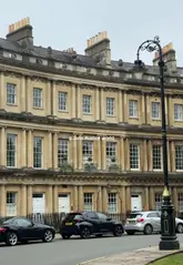 A montage of scenic shots in Bath, including the Pulteney Bridge, followed by shots of tea, breakfast, and elegant interiors, creating a romantic, literary atmosphere.