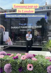 A short, energetic vlog showcasing a Samsung pop-up event in Covent Garden, London. The video highlights interactive experiences including a personalized cookie printer, a claw machine for prizes, and a free drinks station, alongside a hands-on display of new Samsung Galaxy devices.