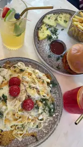 A creator visits a new brunch spot called Monaco in Manchester, showcasing the interior, drinks, and various dishes including pasta, a burger, and french toast.