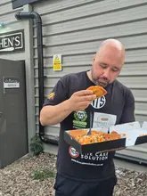 A creator reviews a 'munchbox' takeaway from New Road Kitchen in Nottingham, showcasing the contents including a burger, loaded fries, chicken strips, and tacos.