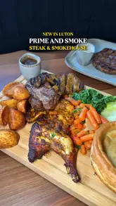 A promotional video for Prime and Smoke in Luton, showcasing a variety of dishes including a Sunday roast platter, steaks, scallops, and desserts, alongside cocktails.
