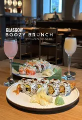 A polished, visually appealing reel showcasing a boozy brunch experience at Sticks'n'Sushi, featuring shots of sushi, skewers, cocktails, and the restaurant interior.