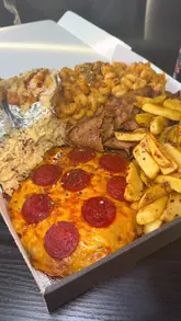 A food review of a 'Munchbox' from Doughboyz Parmo House in Burnage, Manchester, where the creator tastes and rates various items including a parmo, donner meat, mac and cheese, and a parmo toastie.