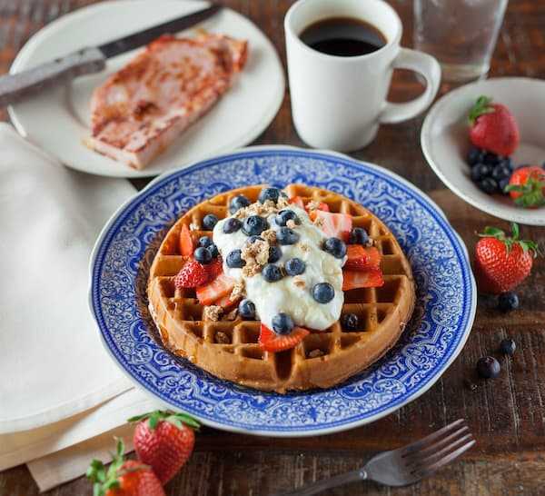 A waffle covered in strawberries in a cafe